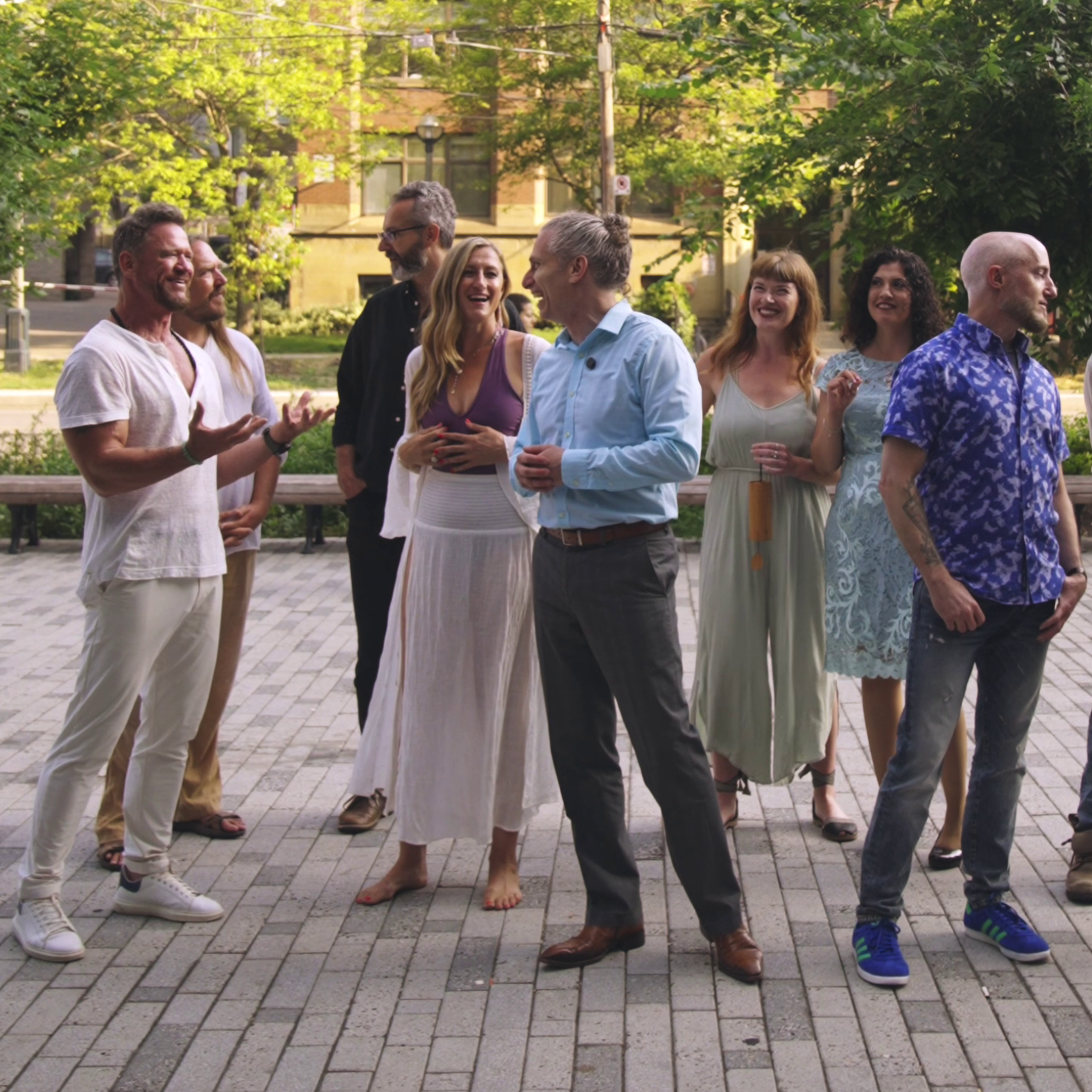 Group of Résone performers at The Well in downtown Toronto, gathered outdoors in a relaxed setting