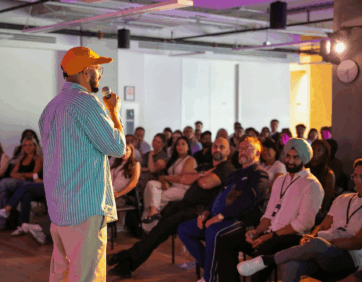 Speaker presenting to a full audience during an indoor event.