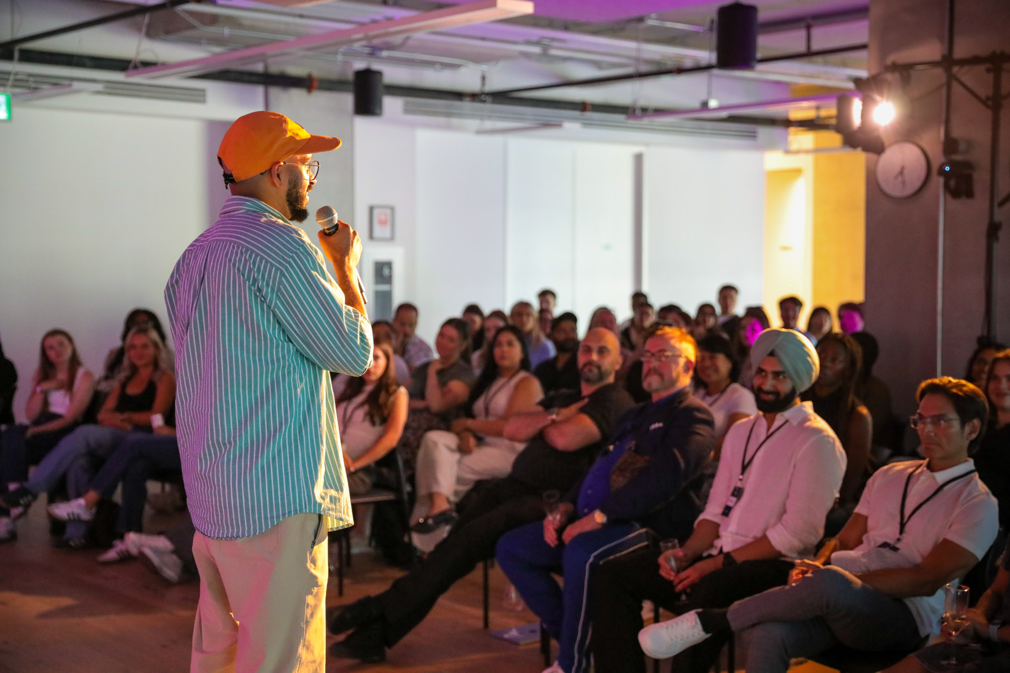 Speaker presenting to a full audience during an indoor event.