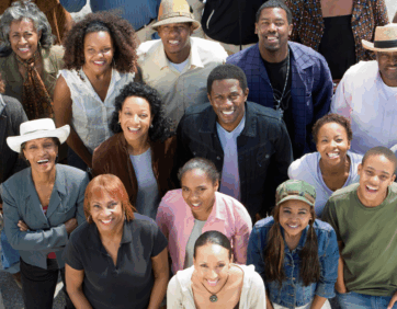 A diverse group of smiling people gathered together at a wellness and community event.